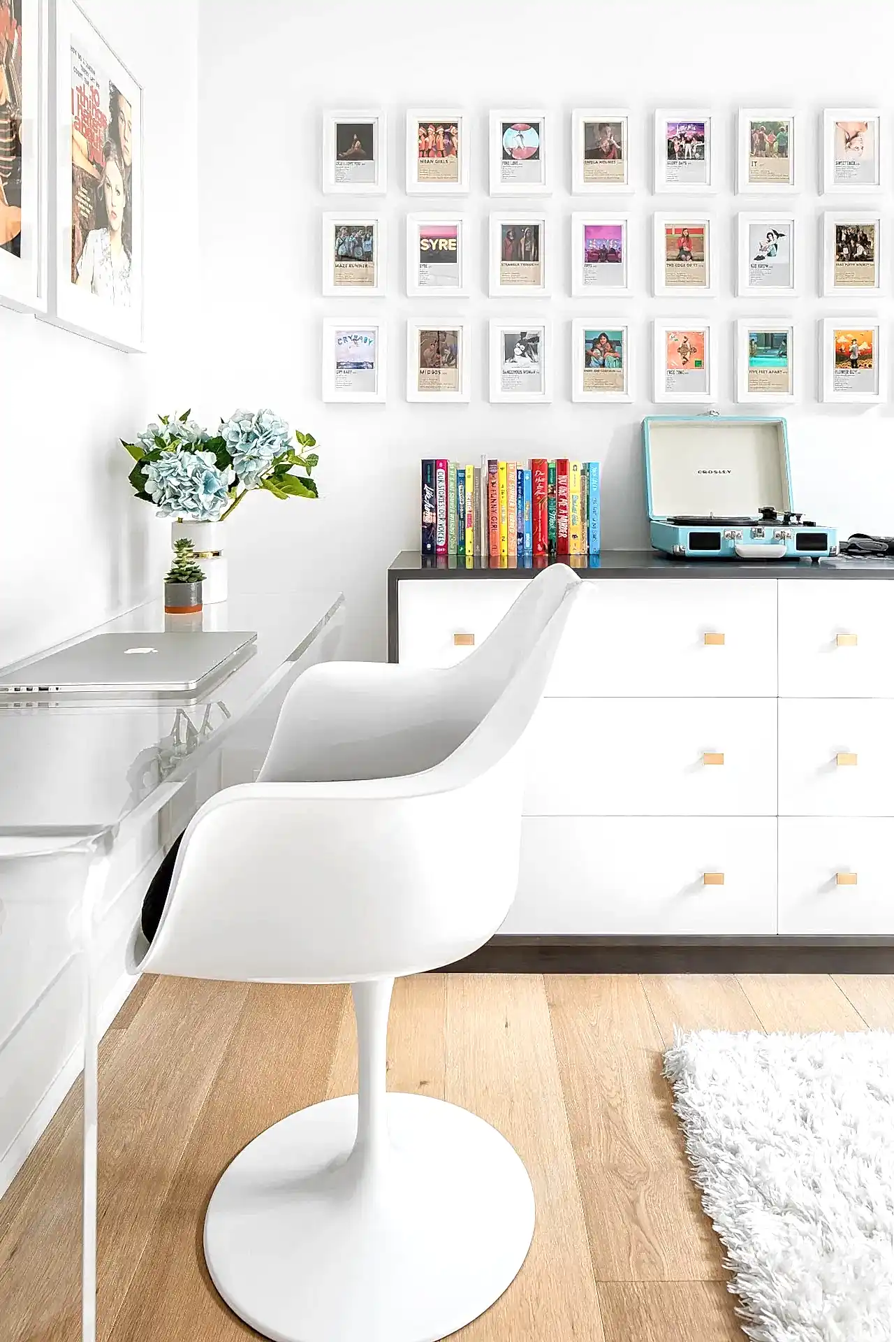 Cozy modern bedroom with white bedsheets and colorful photo gallery wall