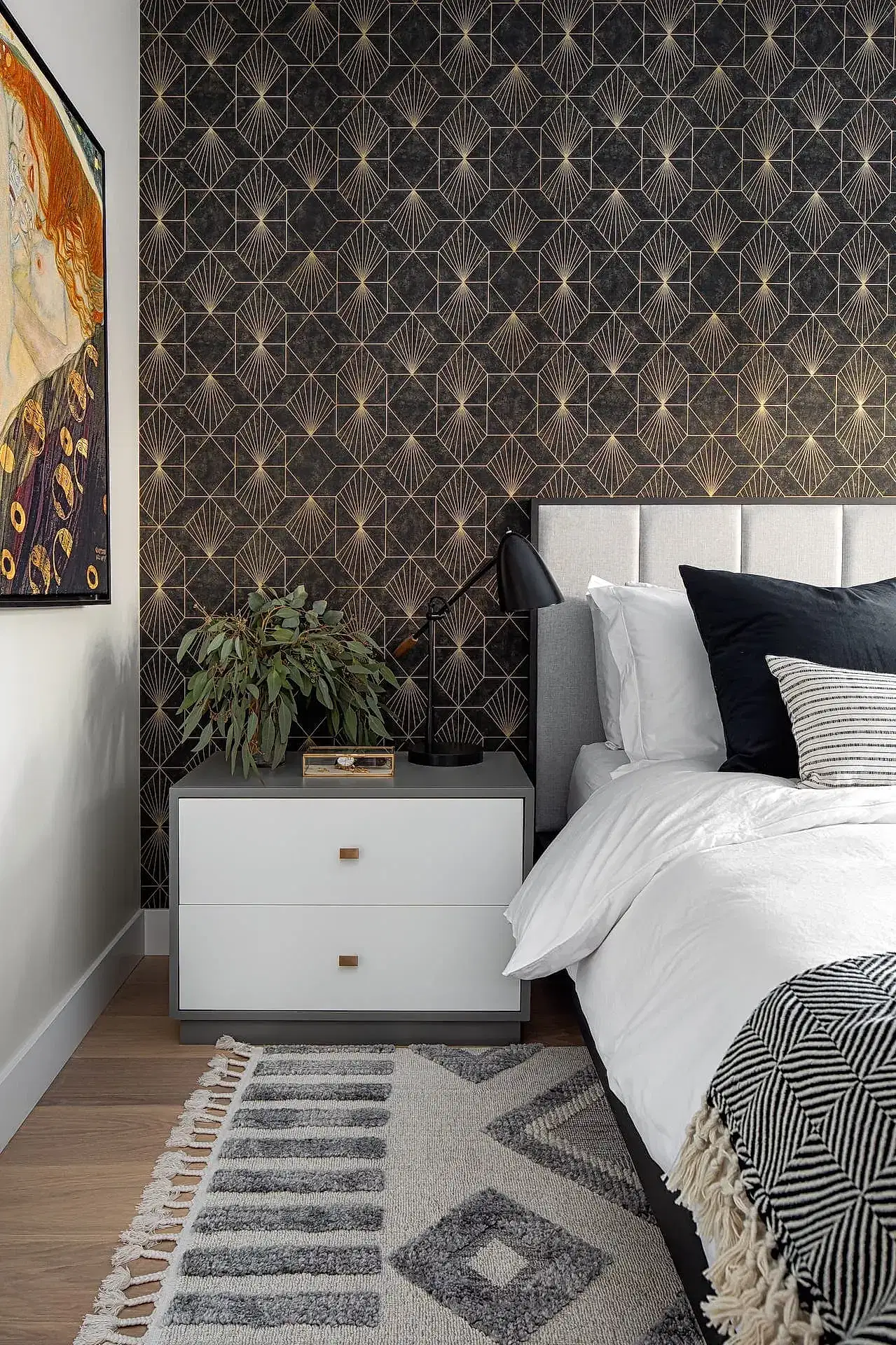 Bright modern contemporary bedroom with white upholstered headboard and bold geometric patterned gold wallpaper
