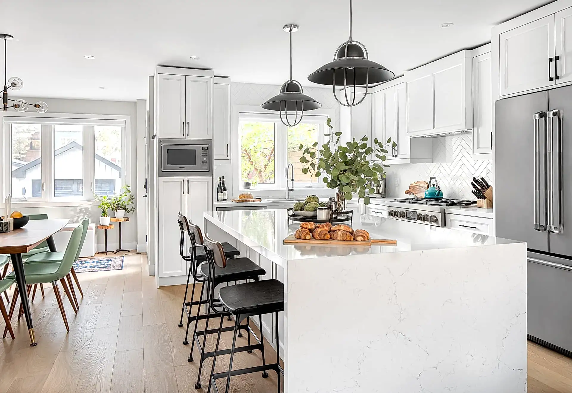 Bright open concept modern transitional kitchen and dining room with large white island and cabinets