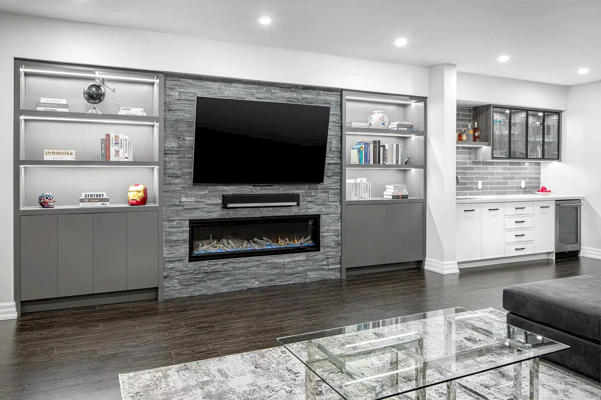 High contrast transitional modern living room and kitchenette with stone feature wall